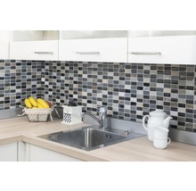 Küchenspüle mit Armatur, Mosaikfliesen-Wand, Kaffeemühle und Geschirr auf einer Arbeitsplatte.