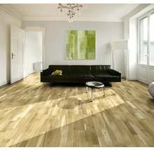 Wohnzimmer mit Holzboden, Sofa und Kunstwerk