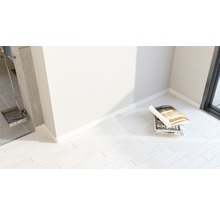 Heller Raum mit Magazinen auf Laminatboden und Kaminbesteck.