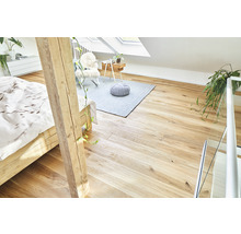 Heller Dachboden mit Holzboden, Bett, Teppich und Sitzgelegenheit