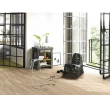 Wohnraum mit Holzboden, Sessel, Tisch und Fenstertüren