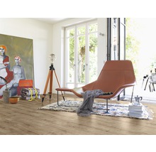 Heller Raum mit Holzboden, Sessel, Lampe und Gemälde