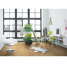 Heller Raum mit Holzboden, großem Fenster, weißem Sessel, Schreibtisch und bunten Kisten