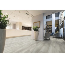 Heller Raum mit Bodenbelag in Holzoptik, Rezeption und Sitzecke