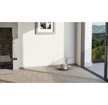 Heller Raum mit Steinboden, Kamin und Blick ins Grüne