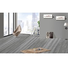 Heller Raum mit grauem Holzboden, Sessel und Teppich