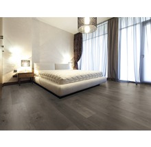 Schlafzimmer mit großem Bett, Nachttisch und Holzboden