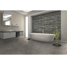 Modernes Badezimmer mit freistehender Badewanne, Waschtisch und Steinwand