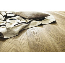 Bodenbelag aus Holz mit Kaffeetasse, Decke und Kissen.