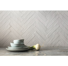 Wandfliesen im Fischgrätmuster als Hintergrund für Geschirr