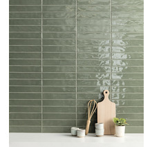 Wandgestaltung mit länglichen, grünen Fliesen im Küchenbereich, kombiniert mit Schneidebrett, Schneebesen und Pflanze