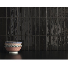 Schwarze Fliesenwand mit gestapelten Schalen