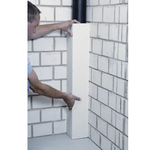 Mann montiert eine Eckleiste an einer gemauerten Wand.