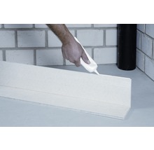 Anwendung von Montagekleber auf einer Sockelleiste