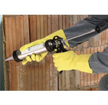 Handwerker benutzt eine Kartuschenpistole an einer Ziegelwand