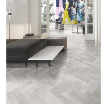 Heller Wohnraum mit Bodenfliesen im Fischgrätmuster.