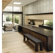 Helles Wohnzimmer mit Küche, Sitzecke und Betonwand