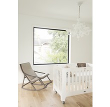 Helles Zimmer mit Babybett, Schaukelstuhl und Fenster