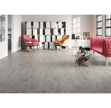 Wohnzimmer mit hellem Holzboden, Sesseln und Regal