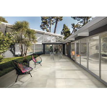 Terrasse mit Gartenmöbeln vor modernem Haus mit Schiebetüren