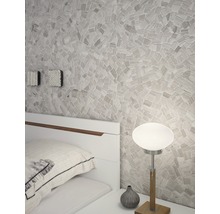 Schlafzimmer mit Mosaikwand, Nachttischlampe und weißem Bett