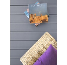 Terrassendielen mit Kissen, Rattankorb und gestapelten Büchern