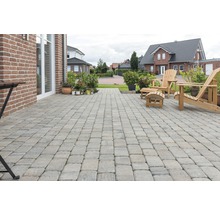 Terrasse mit Pflastersteinen, Gartenmöbeln und Pflanzen