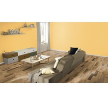 Wohnzimmer mit Sofa, Tisch, Kommode und Wandregalen.