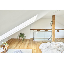 Helles Schlafzimmer im Dachgeschoss mit Dachfenster, Holzbalken und Holzboden