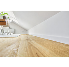 Dachgeschosszimmer mit Holzboden, weißen Wänden und Möbeln