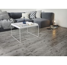 Heller Wohnraum mit grauer Couch, weißem Couchtisch und Holzoptik-Fliesen