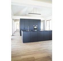 Moderne Küche mit Kochinsel, Spüle und Einbaubackofen in einem hellen Raum mit Holzboden.