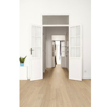 Heller Raum mit Holzboden und geöffneten weißen Flügeltüren.