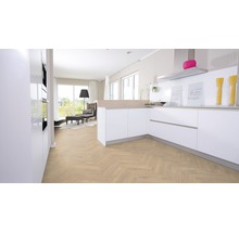 Heller Raum mit moderner Küche und Wohnbereich mit Parkettboden in Fischgrätmuster.