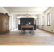 Heller Raum mit Holzboden, Esstisch, Stühlen und Küchenzeile