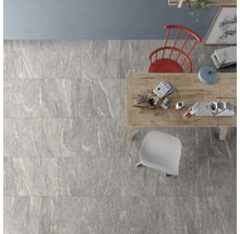 Verlegtes graues Fliesenmuster in einem Raum mit Tisch und Stühlen aus der Vogelperspektive.