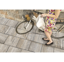 Frau mit Fahrrad auf Pflastersteinen