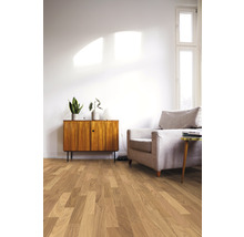 Heller Wohnraum mit Holzboden, Sessel und Kommode