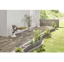 Gartenszene mit Pflastersteinen, Pflanzsteinen, Bank und Pflanzen