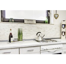 Küchenszene mit Kochfeld, Teekessel, Dekorationen und Küchenutensilien auf einer Arbeitsplatte.