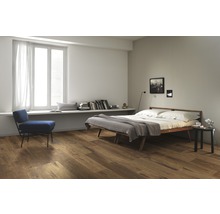 Schlafzimmer mit Holzboden, Bett, Stuhl und Fenster