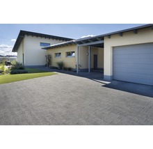 Außenaufnahme eines Hauses mit gepflasterter Einfahrt, Garage und Carport