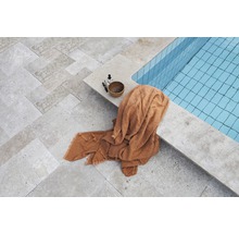 Blick auf einen Pool mit Handtuch und Pflegeprodukten auf dem Steinboden