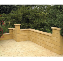 Gartenmauer aus Betonsteinen und Pflastersteinen auf einer Terrasse.