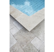 Detailansicht eines Pools mit Travertin Poolumrandung und Bodenplatten.