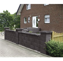 Betonsteinmauer vor einem Wohnhaus mit Pflastersteinen