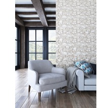 Wohnzimmer mit Sessel, Sofa, Kissen, Decke und Steinwand