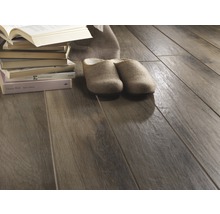 Holzfliesen mit Buchstapel und Hausschuhen auf dem Boden