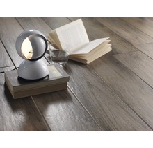 Szene mit Bodenbelag in Holzoptik, Lampe, Buch und Wasserglas.