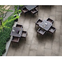 Draufsicht auf einen Außenbereich mit grauen Bodenfliesen und mehreren quadratischen Holztischen mit passenden Stühlen